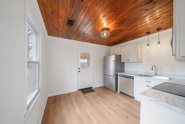 a kitchen with a sink a refrigerator and cabinets