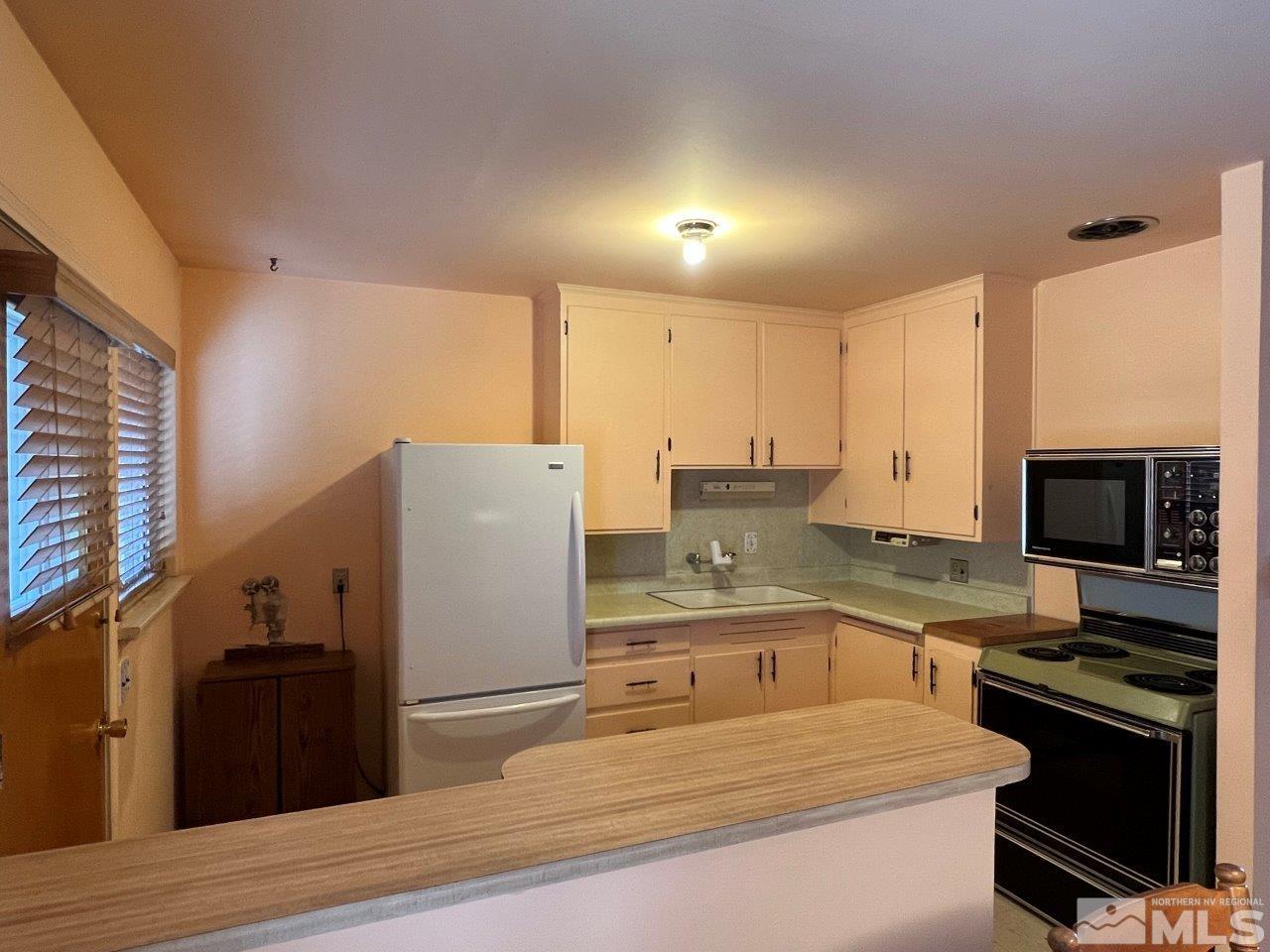 735 Reeves Avenue Reno, NV 89503 - Photo 6 of 15 a kitchen with a refrigerator and a stove top oven