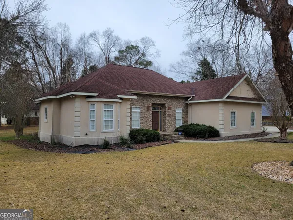 a front view of a house with yard and trees