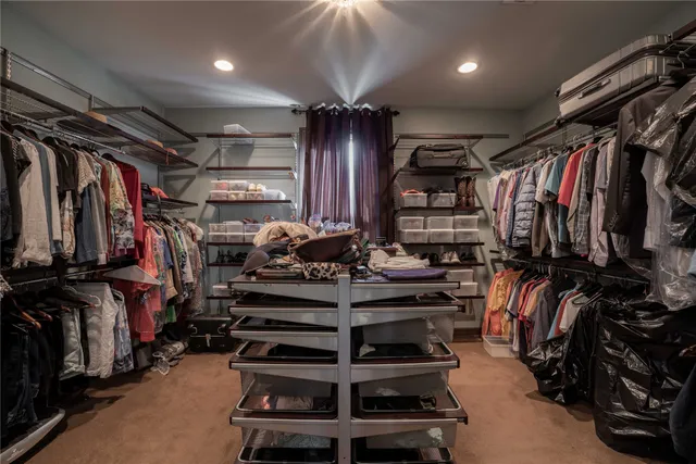 a view of walk in closet with clothes and shoes