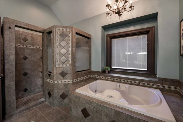 a bathroom with a tub a sink and mirror