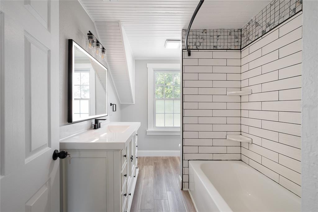 922 Delaware Avenue St. Cloud, FL 34769 - Photo 19 of 31 a bathroom with a sink a bathtub and window