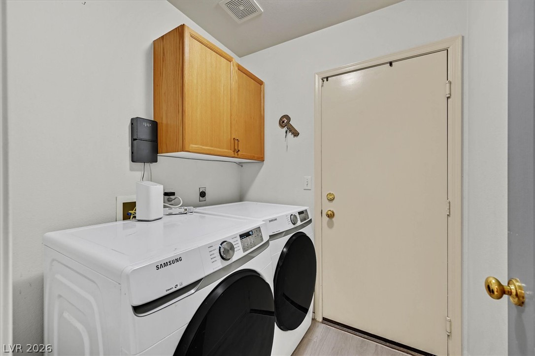 8830 Haviland Road Las Vegas, NV 89123 - Photo 23 of 43 A dedicated laundry space features overhead wood cabinetry and direct exterior access.
