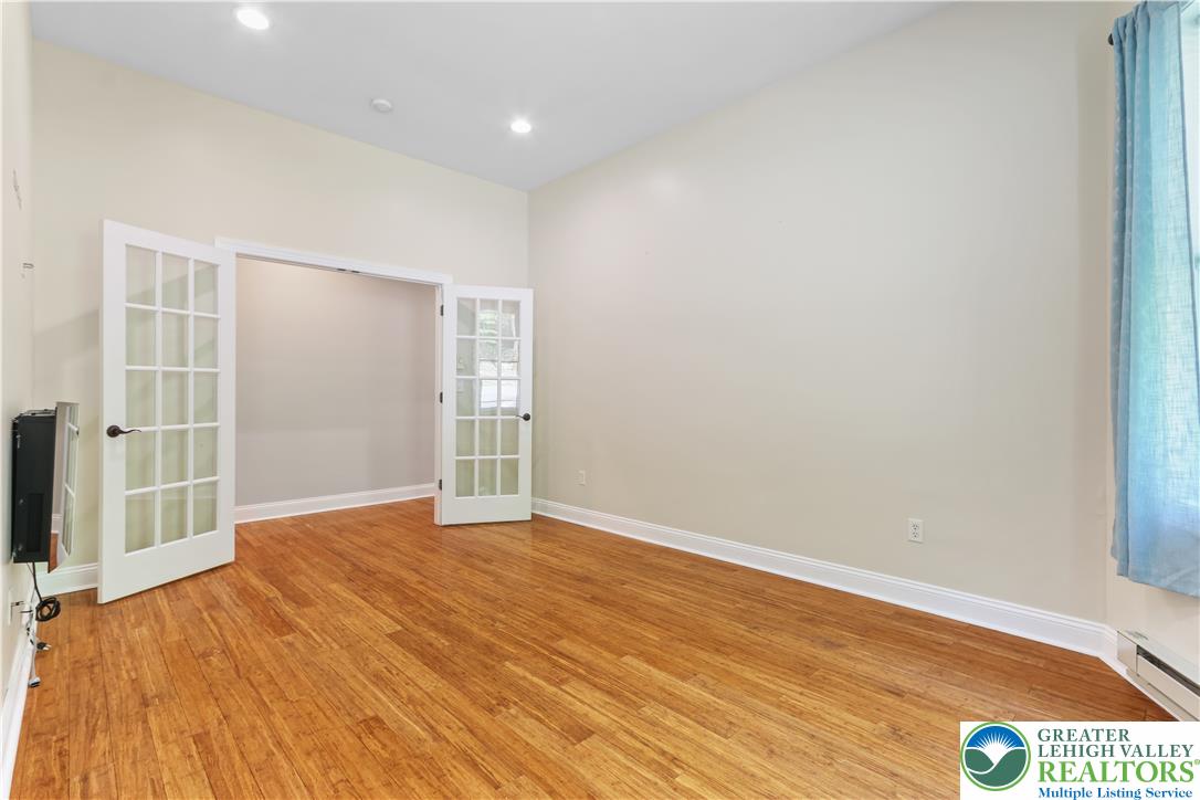 1007 Hampstead Road Bushkill, PA 18324 - Photo 15 of 72 French doors open into a versatile space, featuring rich hardwood flooring and recessed lighting.