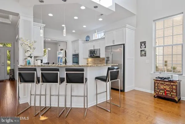a kitchen with stainless steel appliances kitchen island granite countertop a refrigerator and cabinets