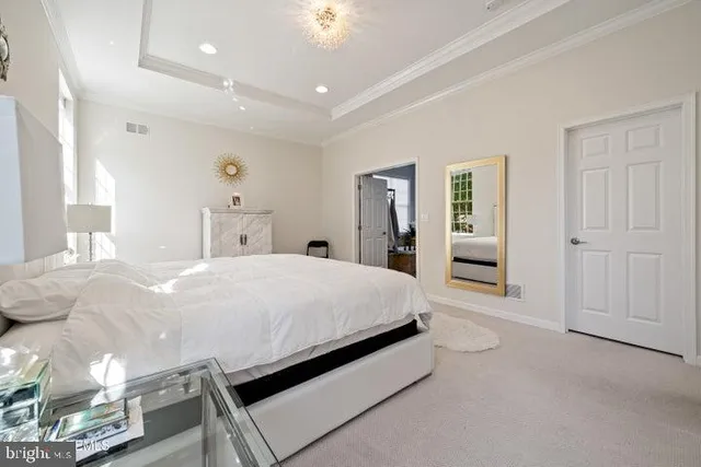 a spacious bedroom with a bed and a chandelier