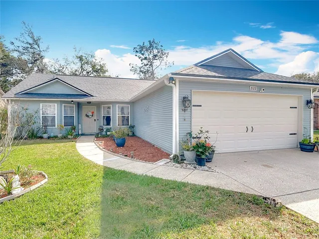 an aerial view of a house with swimming pool and large trees