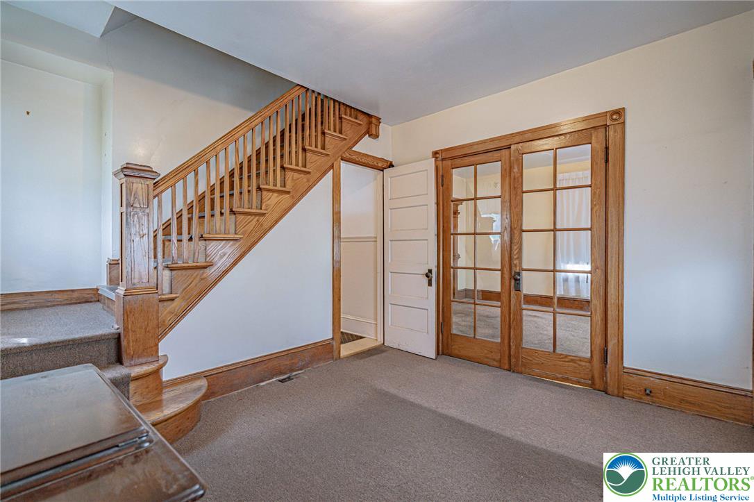 159 West Ridge Street Nesquehoning, PA 18240 - Photo 7 of 55 A well-maintained wooden staircase and French doors create a charming and inviting entryway.