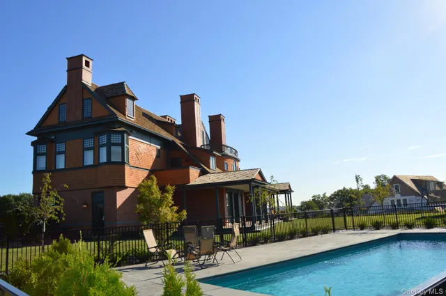 a front view of a house with swimming pool having outdoor seating