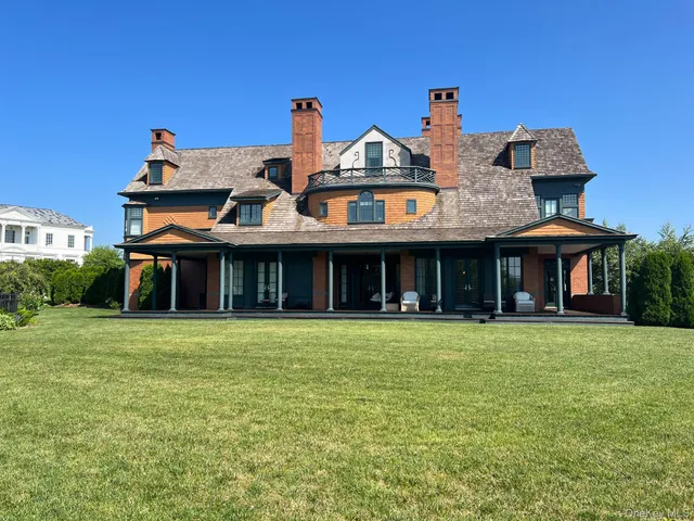 a view of a big house with table and chairs