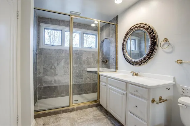 a bathroom with a sink a mirror a vanity and a shower