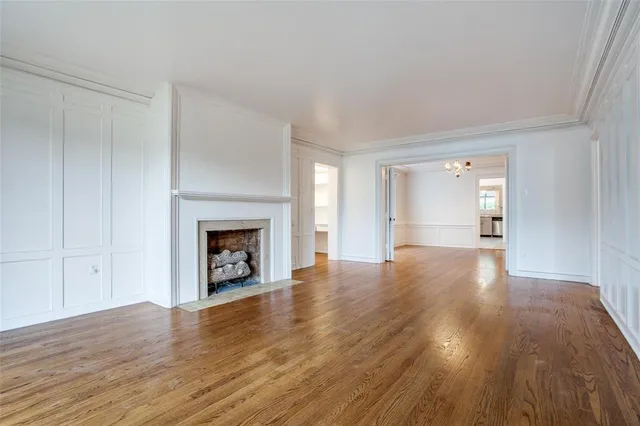 a view of a livingroom with wooden floor and a fireplace