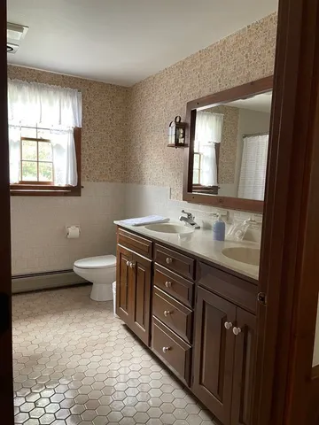 a bathroom with a granite countertop sink a toilet and mirror
