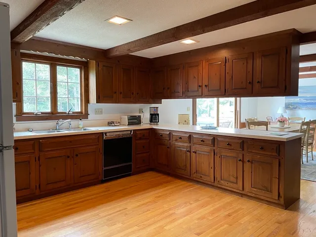 a kitchen with granite countertop wooden cabinets a sink and dishwasher