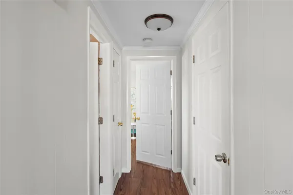 a view of a hallway with wooden floor