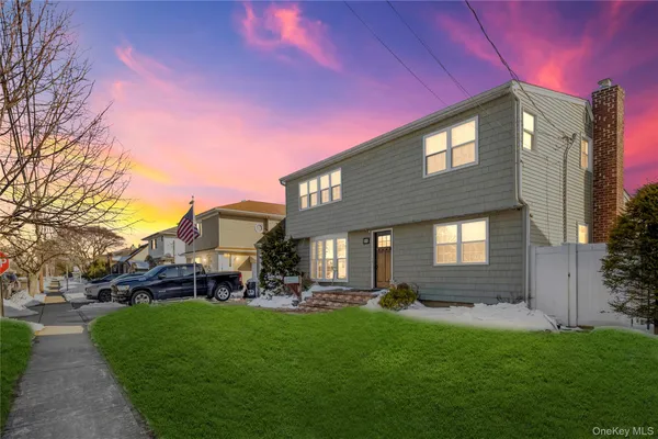 a front view of a house with a garden and yard