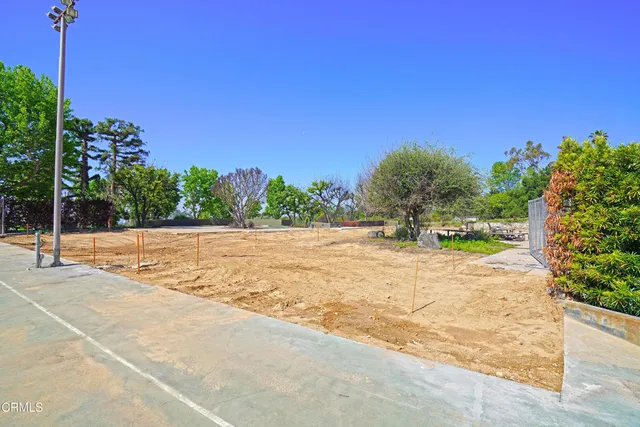 a view of swimming pool with outdoor seating and trees in the background