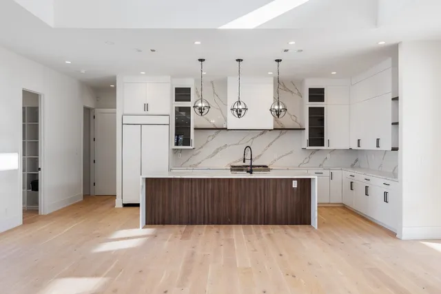 a kitchen with stainless steel appliances granite countertop a sink a oven and wooden floors