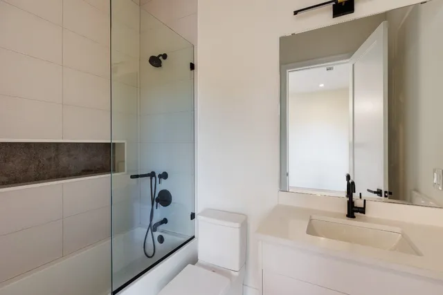 a bathroom with a sink a toilet and shower