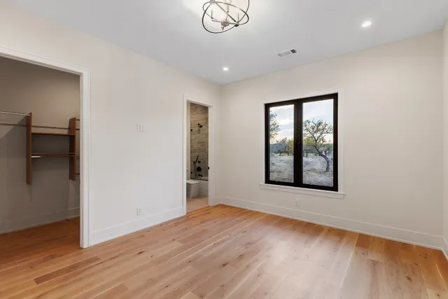 a view of a bedroom with a bed and wooden floor
