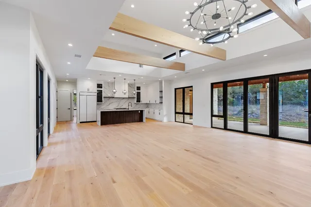 a kitchen with stainless steel appliances granite countertop a sink a stove and a wooden floors