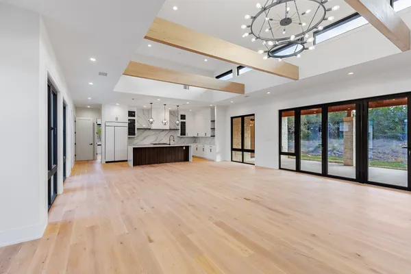 a large kitchen with cabinets a sink a window and stainless steel appliances