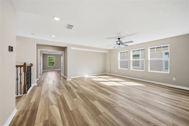 a view of empty room with wooden floor and windows