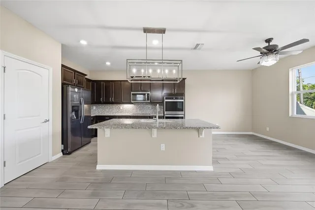 a view of a kitchen with a sink stainless steel appliances and cabinets
