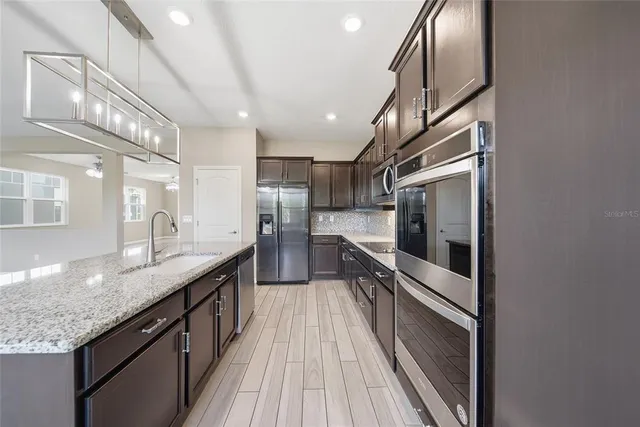 a kitchen with stainless steel appliances granite countertop a sink and stove