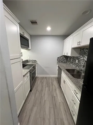 a kitchen with a sink a microwave a stove and refrigerator