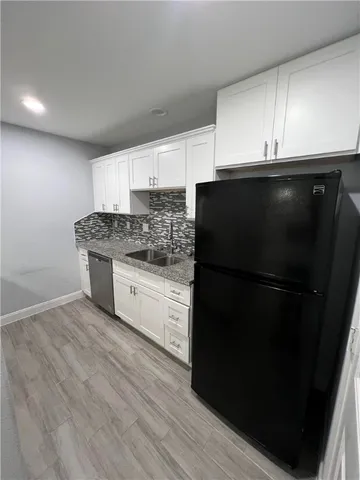 a kitchen with a sink a refrigerator and cabinets