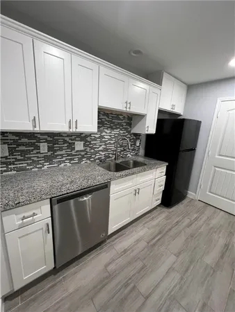 a kitchen with granite countertop white cabinets and white appliances