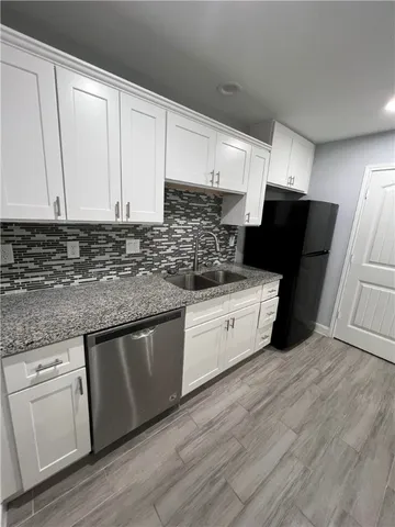 a kitchen with granite countertop white cabinets and white appliances
