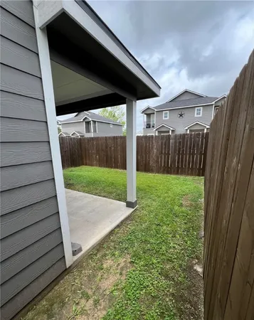 a view of a backyard with wooden fence