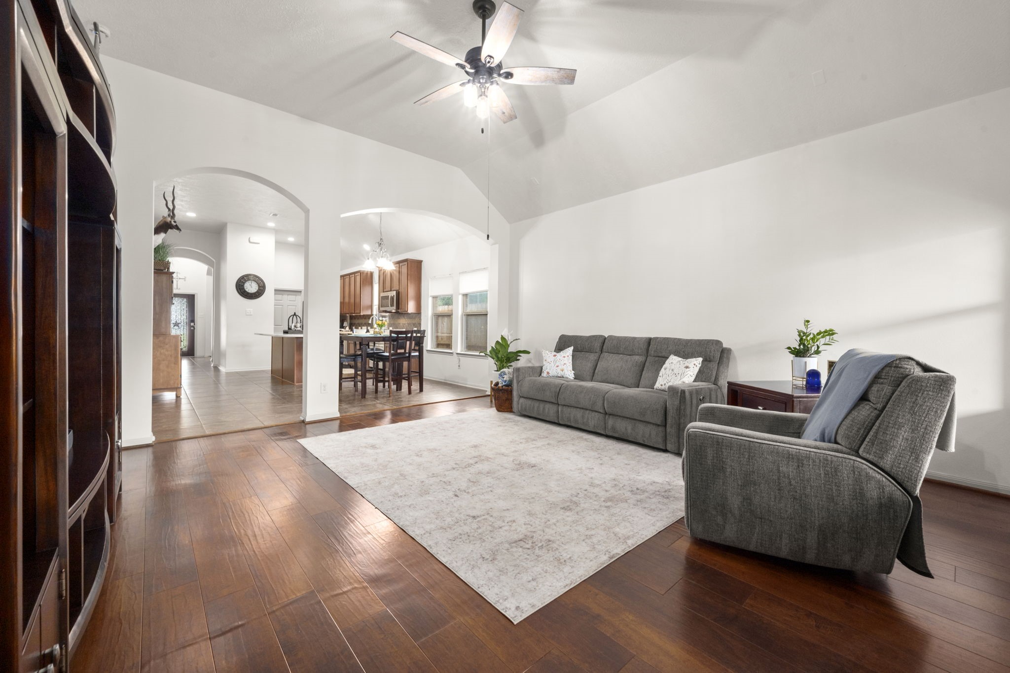 27526 Gatlin Lane Spring, TX 77386 - Photo 21 of 31 Bright and open, this living room showcases hardwood floors and natural light, connecting beautifully to the kitchen and dining area through elegant archways.