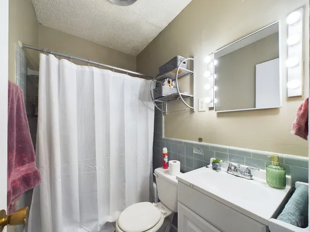 a bathroom with a sink toilet and a mirror
