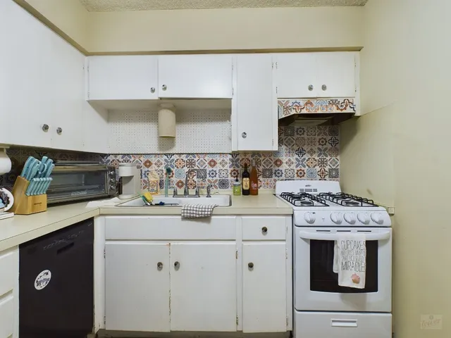 a kitchen with a stove top oven sink and cabinets