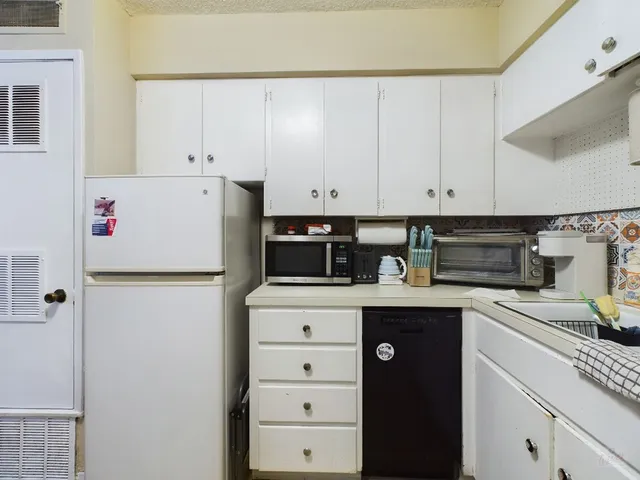a kitchen with refrigerator and cabinets