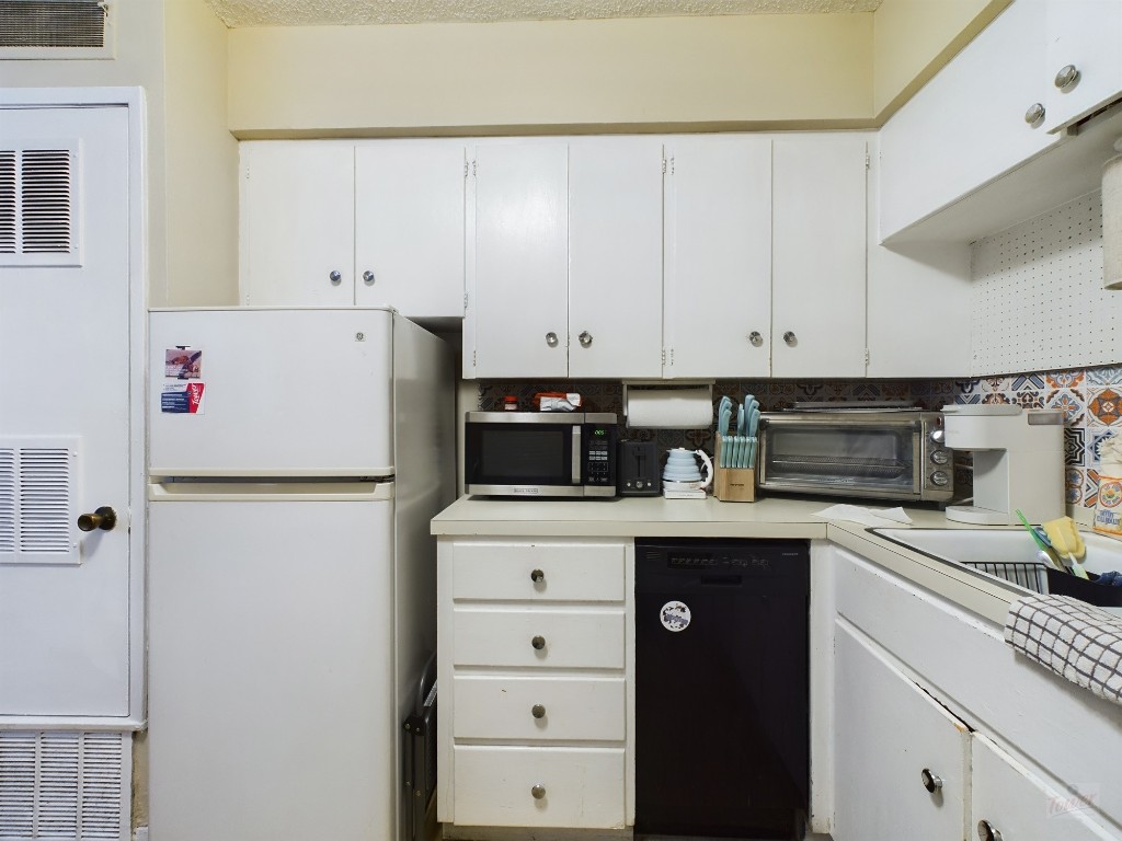 803 West 28th Street, Unit 105 Austin, TX 78705 - Photo 9 of 40 a kitchen with refrigerator and cabinets