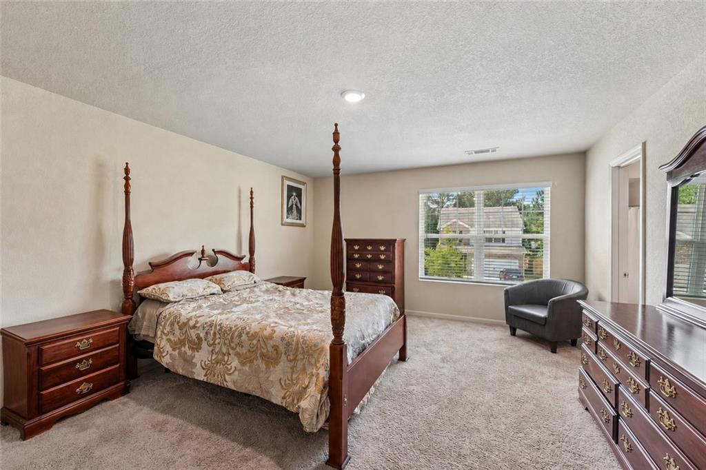 10933 Wheeler Trace Hampton, GA 30228 - Photo 14 of 22 a bedroom with a bed a couch and a window