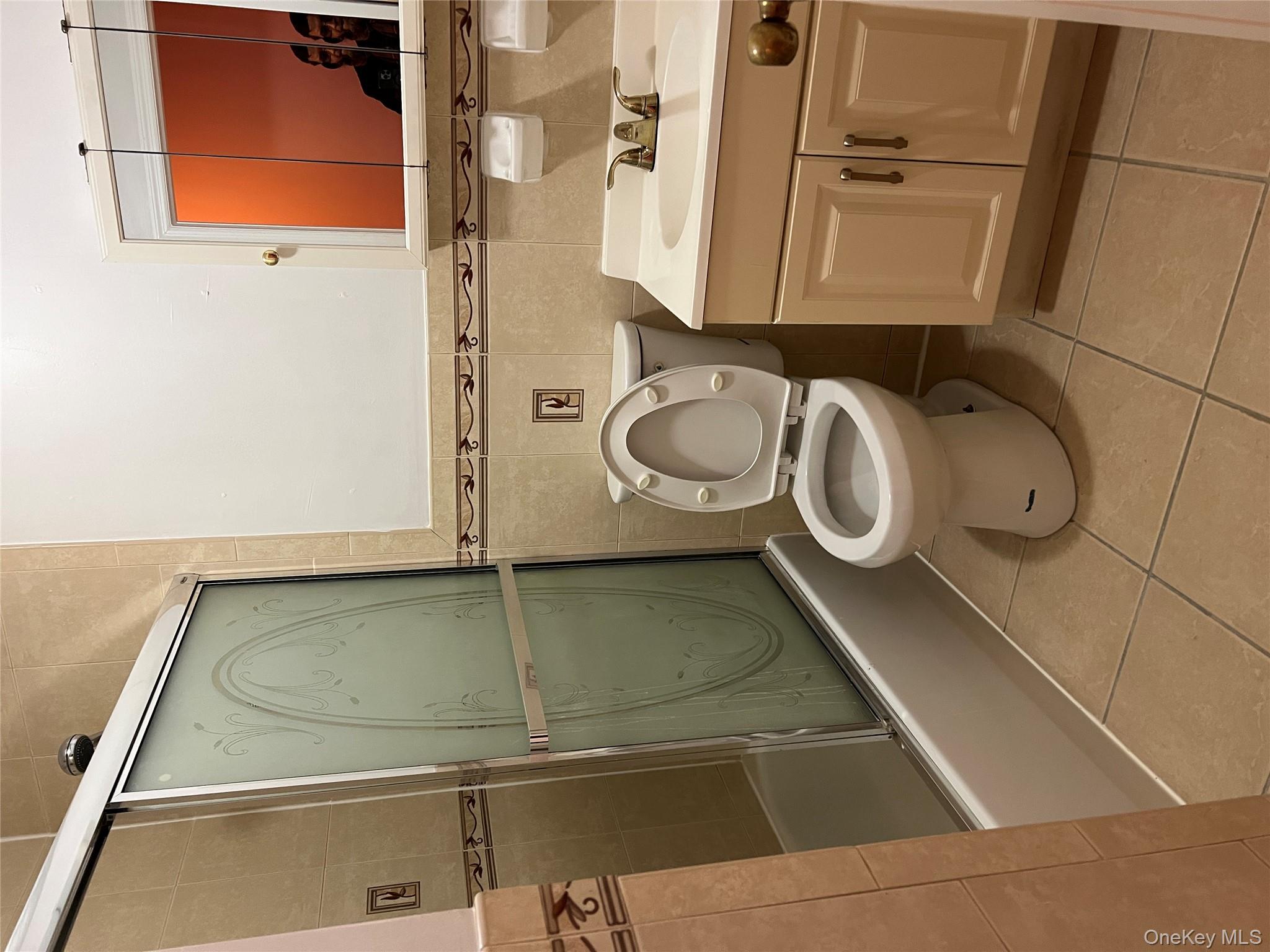 169-11 105th Avenue, Unit 1 Queens, NY 11433 - Photo 7 of 10 a bathroom with a toilet and a sink