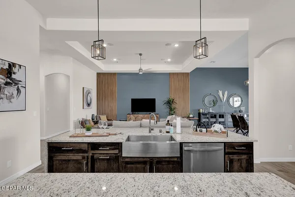 a living room with furniture a kitchen view and a chandelier