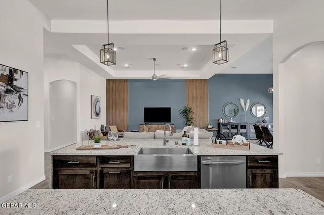 a living room with furniture a kitchen view and a chandelier
