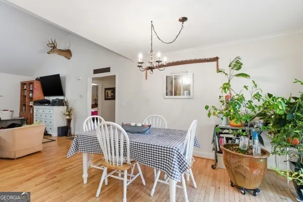 a view of a livingroom with furniture a flat screen tv and wooden floor