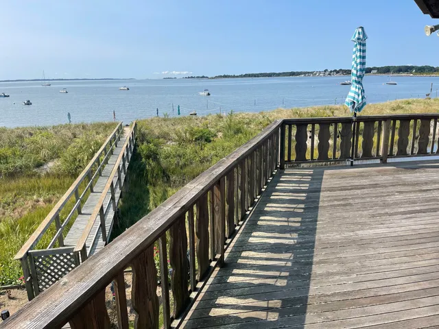 a view of a balcony with wooden chairs and a potted plant