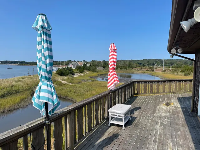 a kitchen with stainless steel appliances granite countertop a sink a stove a dining table and chairs