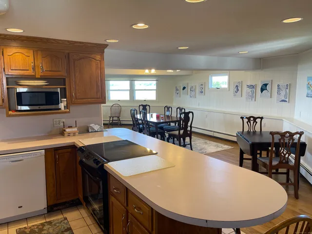 a kitchen with sink a refrigerator and chairs