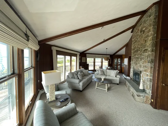 a view of a dining room with furniture large windows and wooden floor