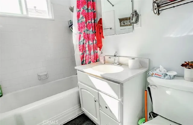 a bathroom with a sink toilet vanity and tub