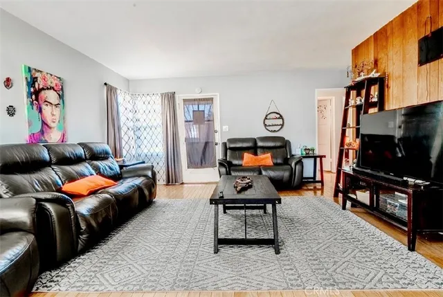 a living room with furniture a flat screen tv and a rug